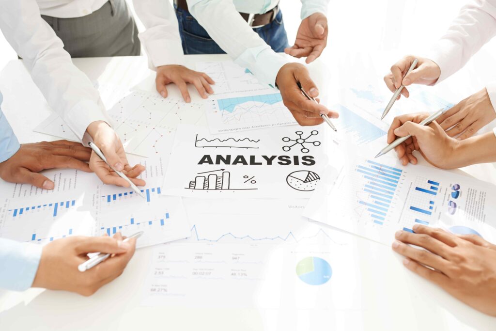 Team of SEO professionals analyzing data and working with charts and graphs on a white table.